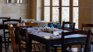A dining area with wooden tables and chairs, a decorative mirror, and a sign indicating coffee and tea service. - The Figolla Farmhouse - Gizimina 1 (Ix-Xagħra)