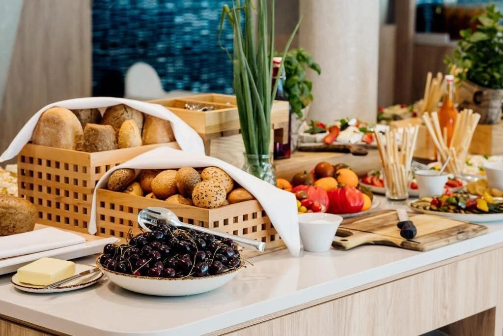 Un tavolo per buffet con diversi cibi, tra cui pane, uova e frutta.