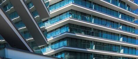 Un hotel moderno con múltiples balcones y fachada de vidrio.