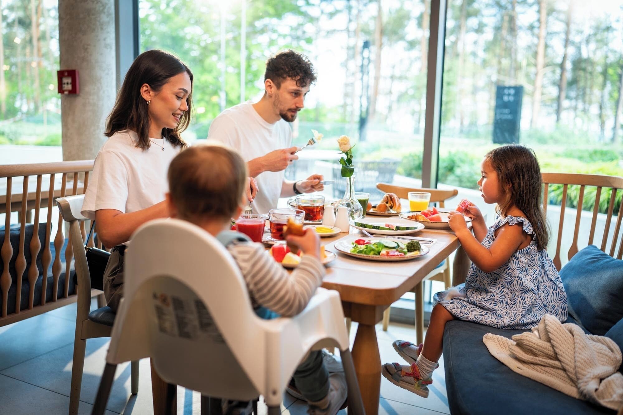 A family dining at a table with a view of the outdoors.