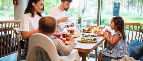 A family dining at a table with a view of the outdoors.