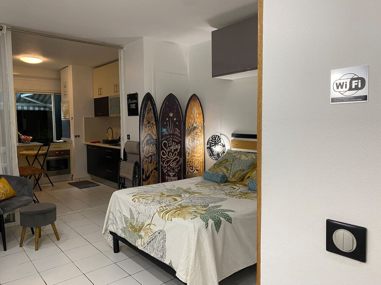 Une chambre comprenant un lit, un bureau et un coin cuisine.
