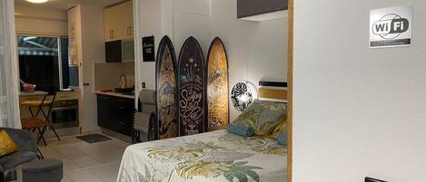 Une chambre comprenant un lit, un bureau et un coin cuisine.