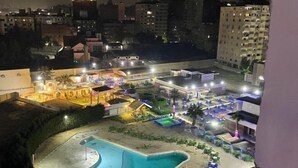 Un hotel con piscina, mobiliario exterior y un patio bien iluminado.