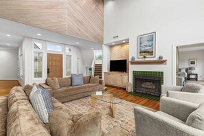 Una sala de estar moderna con sofá, sillones, una mesa de centro y chimenea.