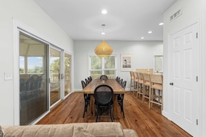 A dining area with a wooden table, black chairs, and a woven pendant light.