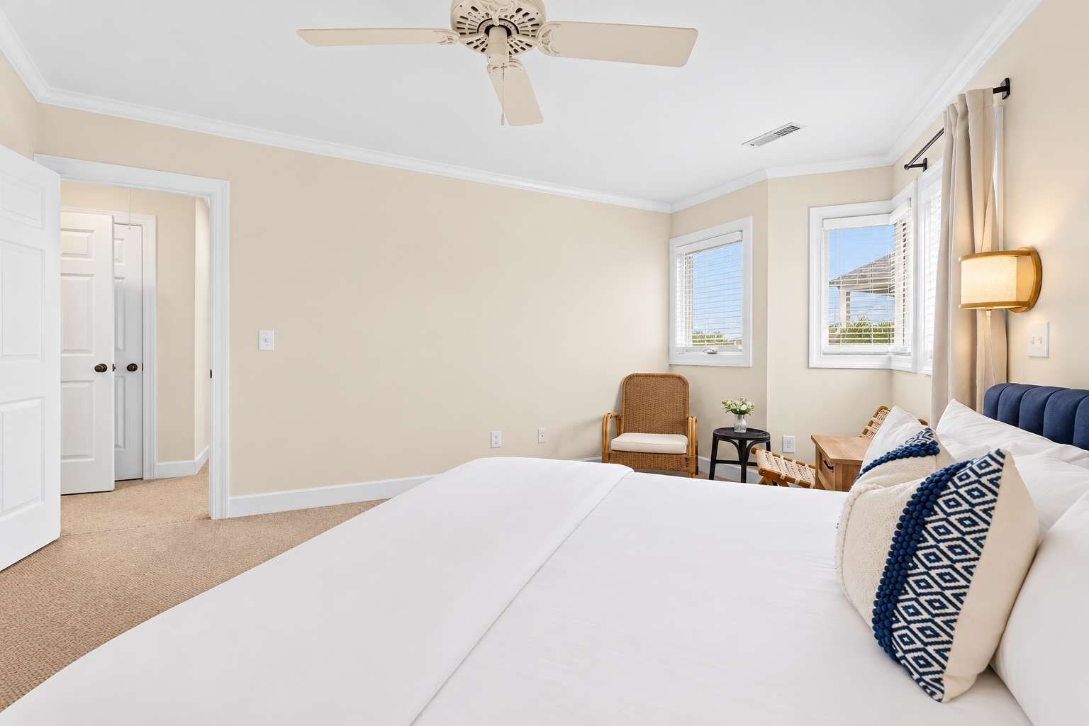 Una habitación de hotel con una cama, una silla, una mesita y una ventana.