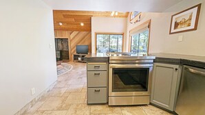 A modern kitchen with a built-in oven, a stove, and a large window providing natural light. - Red Fir 20 - Cabin + ADU, SHARC, Hot Tub, A/C, Bikes (Sunriver)