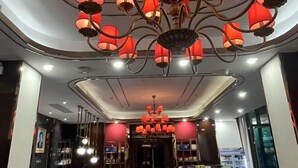 A modern interior with a central chandelier and recessed lighting. - Meihao Hotel (Sihanoukville)