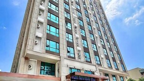A tall, modern building with multiple floors and large windows. - Meihao Hotel (Sihanoukville)