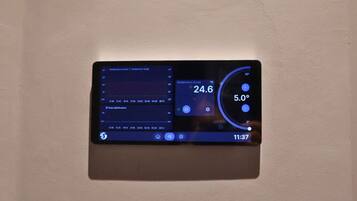 A digital thermostat displaying temperature settings and time.