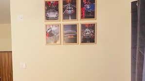Un sofá rojo en una habitación con seis cuadros en la pared.