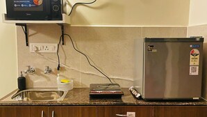 Una cocina con microondas, refrigerador, lavaplatos y armarios de madera.