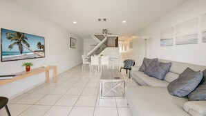 A modern living room with a sofa, coffee table, and a dining area with chairs and a table. - Waterside Retreat in Fort Lauderdale (Fort Lauderdale)
