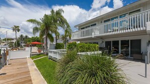 A modern building with a wooden deck, a white balcony, and lush greenery. - Waterside Retreat in Fort Lauderdale (Fort Lauderdale)