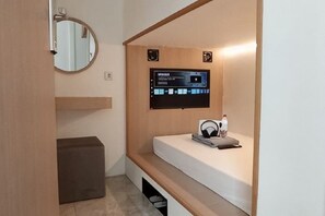 A modern bathroom with a built-in sink, a mirror, and a digital display. - SHAKTI SLEEP YOGYA (Ngampilan)