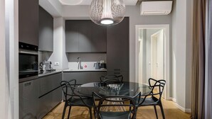 Une cuisine moderne avec une table et des chaises, un four et un luminaire suspendu.