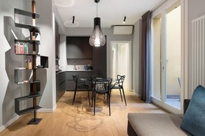 Eine moderne Wohnung mit Essbereich, Küche und einem Balkon mit Vorhängen.