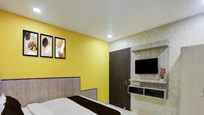 A hotel room with a bed, a TV mounted on the wall, and artwork on the wall. - Hotel O Medical College Basaratpur Gorakhpur (Gorakhpur)