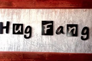 En vägg med texten ”Hug Fang” i svarta bokstäver mot en strukturerad bakgrund.