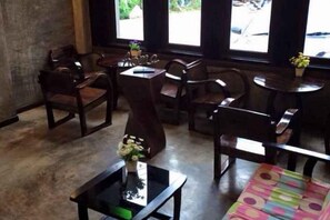 A room with wooden furniture, a concrete floor, and a window with a view. - Hug Fang Hotel (Fang)