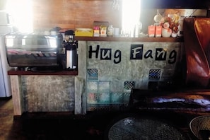A bar area with a counter labeled 'Hug Fang,' a coffee machine, and various bar tools.