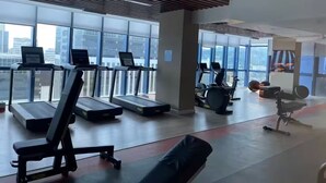 Une salle de sport équipée de tapis de course, d’un vélo d’appartement et d’un rameur.