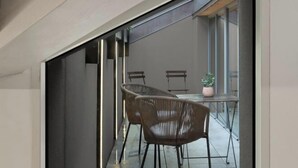 A modern interior with a glass partition, a dining table with chairs, and a potted plant. - The Golden loft by Aura Luxury Collection (Como)
