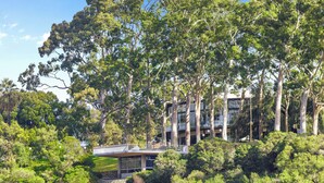 A modern house surrounded by dense trees. - CBD Edge 1BR on Mounts Bay Road (Perth)