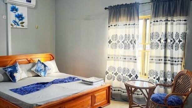 A bedroom with a wooden bed, a small round table, and a chair. - Estepona Playa (Accra)