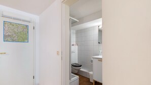 Une salle de bain avec des toilettes, une douche et un lavabo.