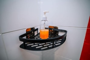 Un bagno con un dispenser di sapone nero e un contenitore di vetro per sapone su un vassoio nero.