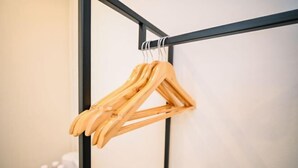Un porte-manteaux en bois muni de plusieurs cintres.