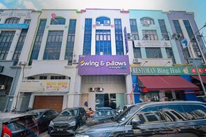 Un immeuble abritant plusieurs commerces, notamment un hôtel, un restaurant et un magasin appelé « Swing & Pillows ».