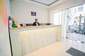 A reception desk with a digital screen, flags, and a window to the outside. - Swing & Pillows @ KL Kuchai Lama (Kuala Lumpur)