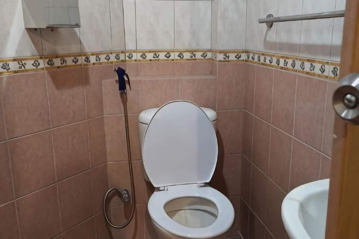 Un baño pequeño con inodoro, bidé y baranda.