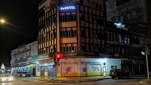 Hotel amb un rètol que diu 'Ae Hotel' de nit, amb una façana moderna, diversos pisos i una entrada destacada.