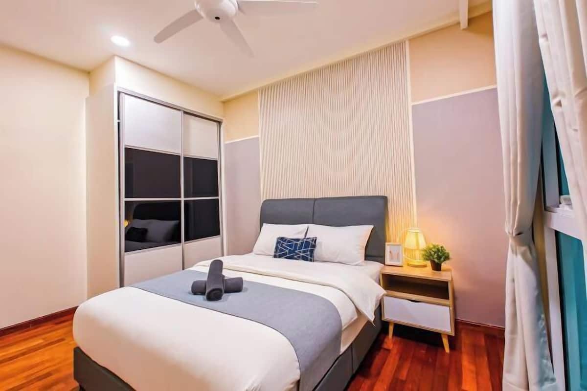 Un dormitorio con cama, mesita de noche, ventilador de techo y puerta corrediza.