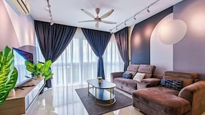 A modern living room with a sofa, a coffee table, and a ceiling fan. - Medini Signature Suites by RR JBcity (Iskandar Puteri)