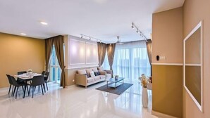 A modern living room with a dining area, a sofa, and a coffee table. - Medini Signature Suites by RR JBcity (Iskandar Puteri)