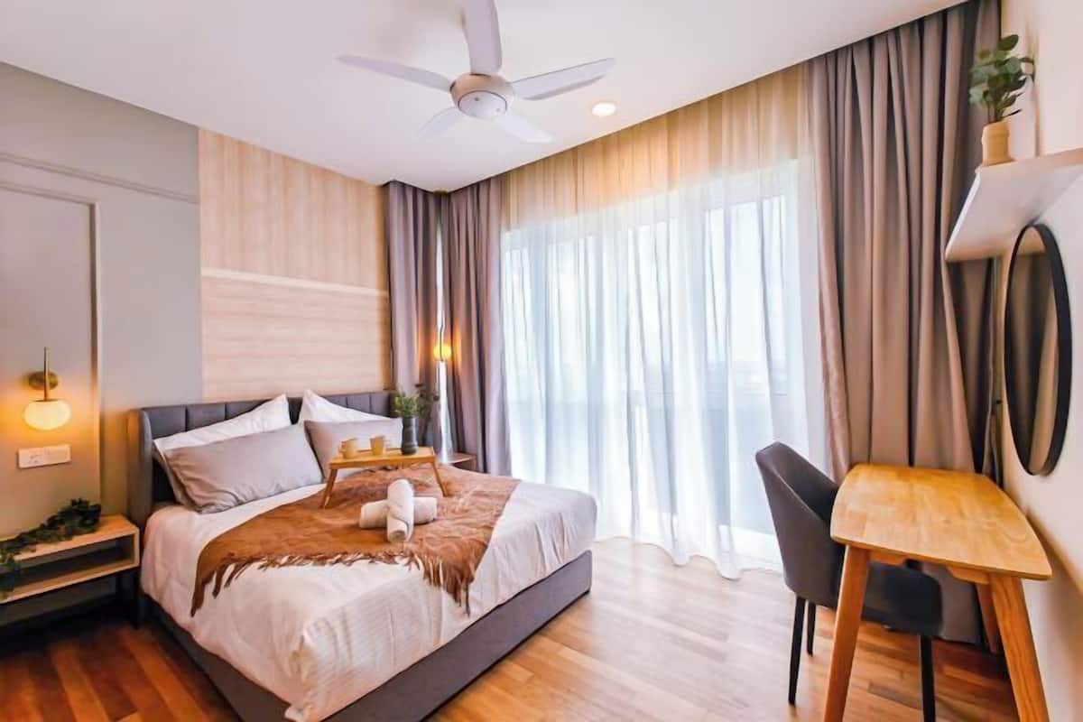 Un dormitorio moderno con cama, mesita de noche, lámpara y un escritorio con silla.