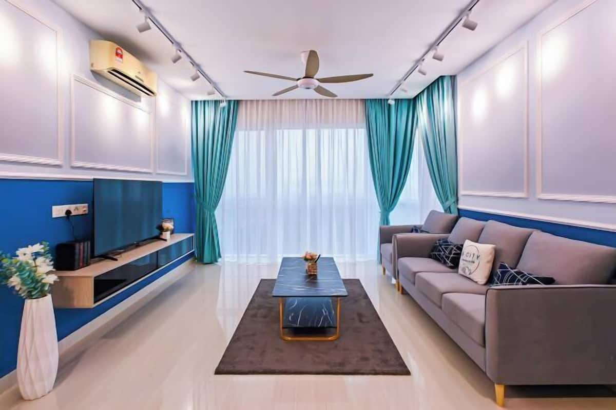 Una sala de estar moderna con televisor de pantalla plana, ventilador de techo y sofá.