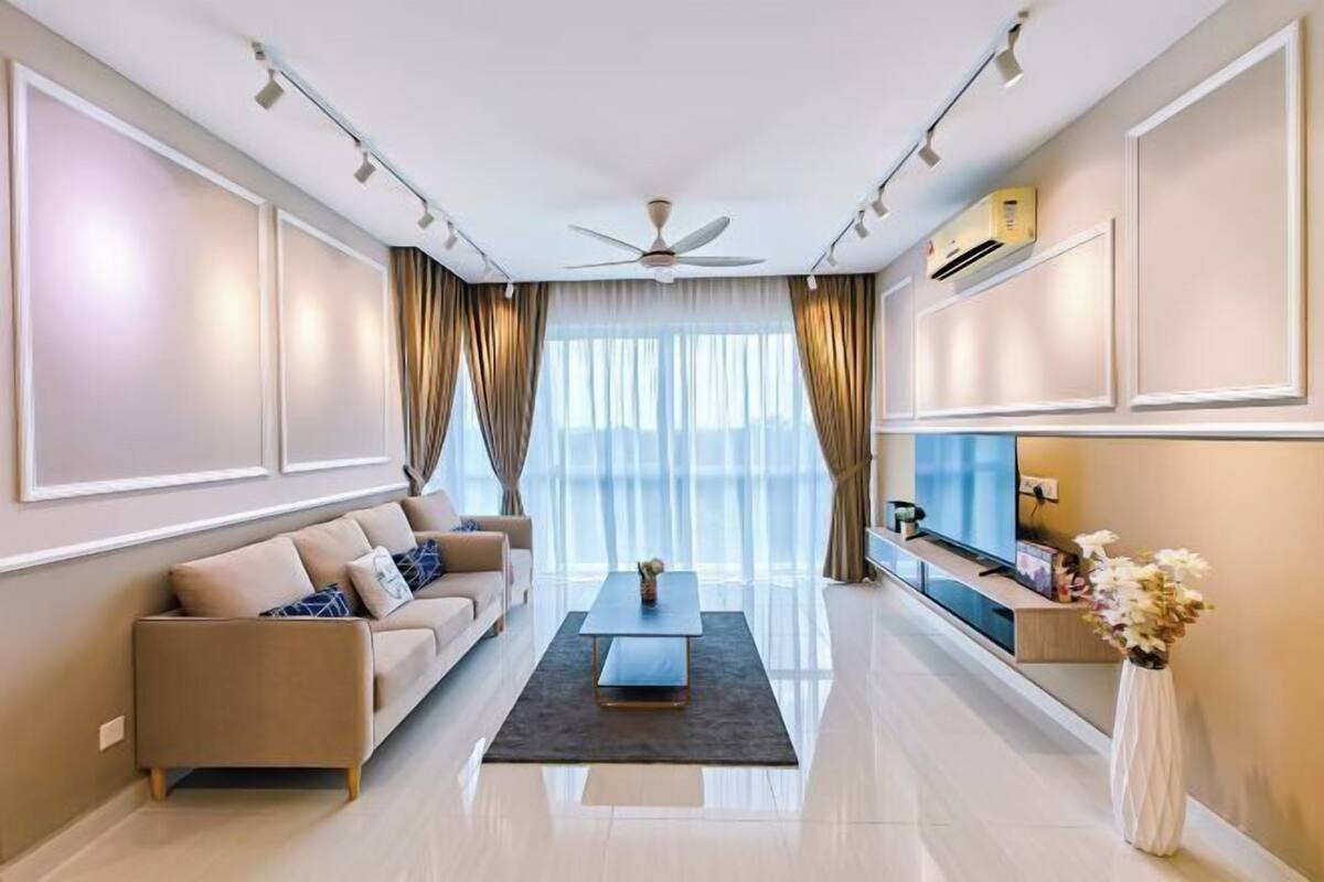 Una sala de estar moderna con sofá, mesa de centro, televisor y un jarrón decorativo.