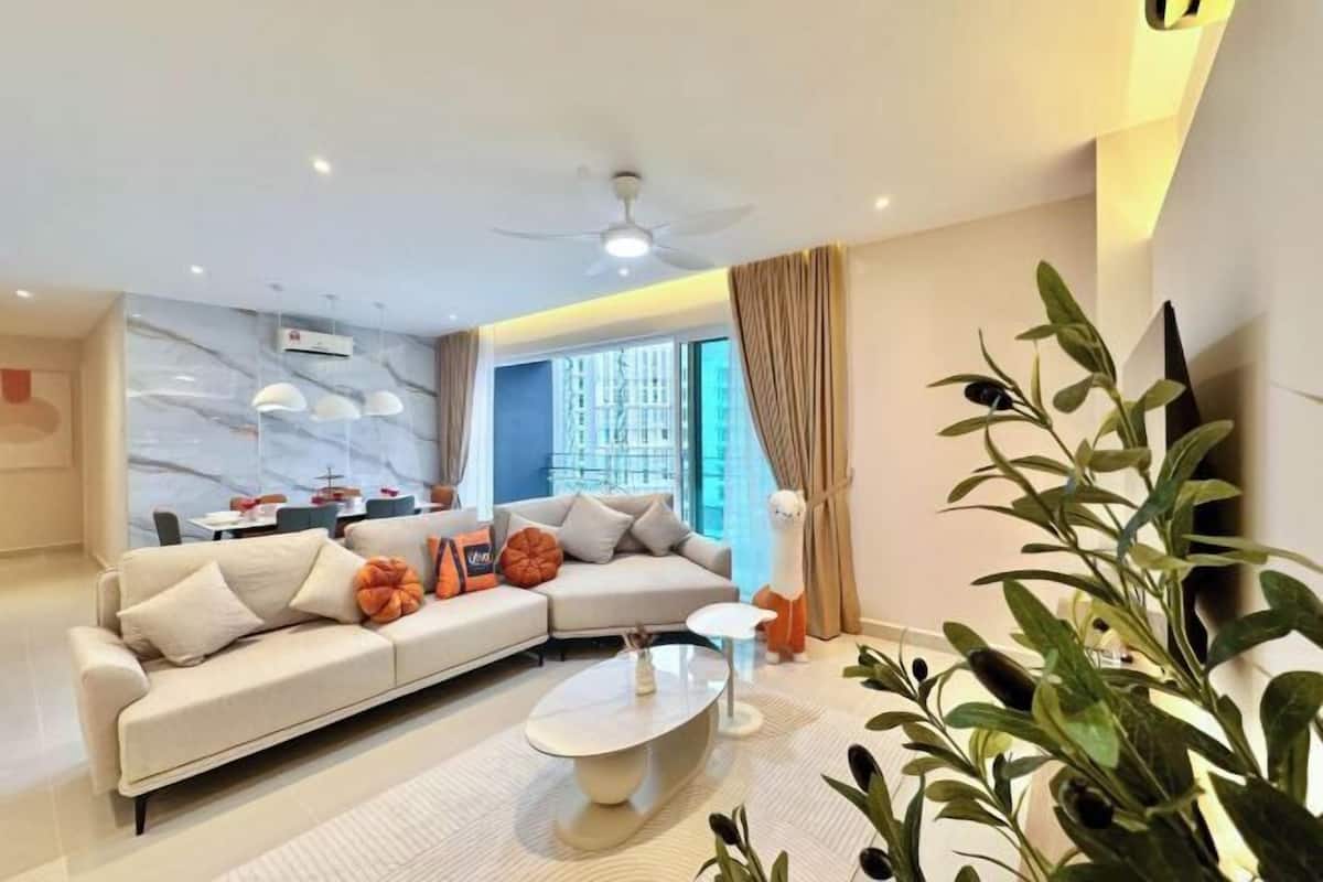 Una sala moderna con un sofá modular, una mesa de centro y una planta.