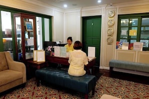 Un área de recepción con escritorio, banca y sofá.