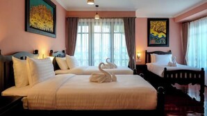 A hotel room with two beds, a large window with curtains, wall art, and a hanging light fixture. - Siri Heritage Bangkok Hotel (Bangkok)