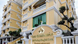 A multi-story hotel with a yellow facade, balconies, and a sign indicating it is the Sirir Heritage Bangkok Hotel. - Siri Heritage Bangkok Hotel (Bangkok)