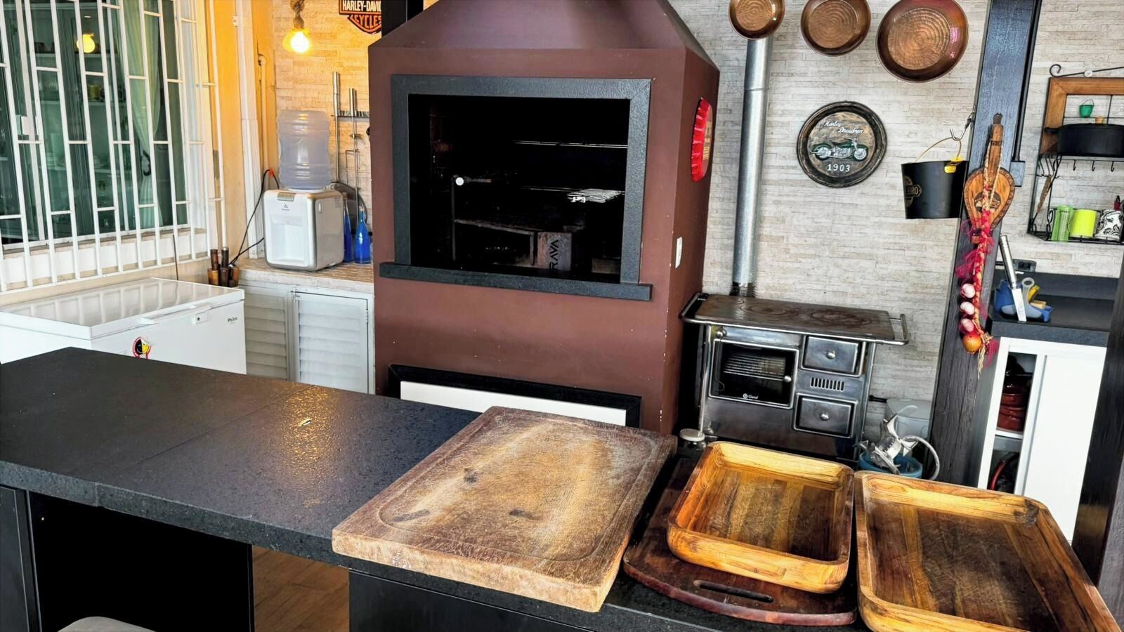 Een keuken met een houtgestookte oven, een waterdispenser en een koffieapparaat.