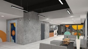 Un hall d’entrée moderne avec un comptoir d’accueil, un espace salon et une grande plante.