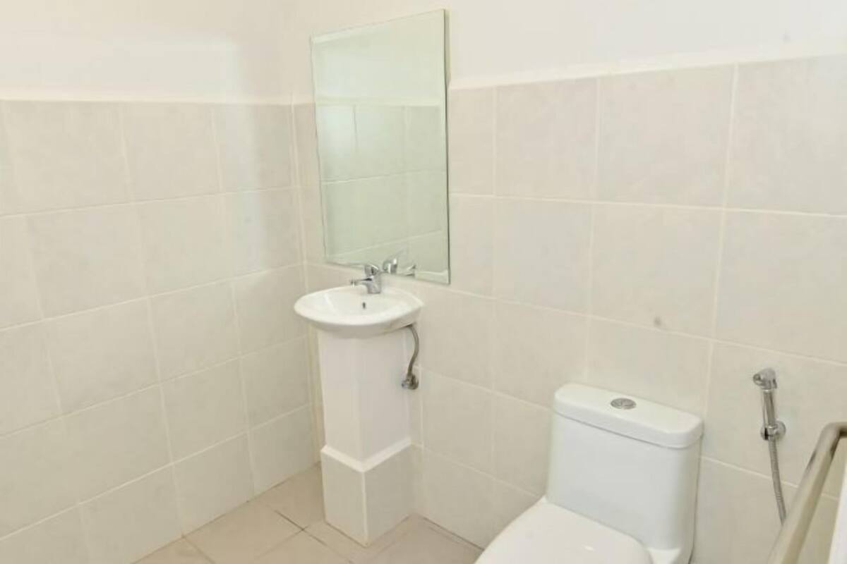Un baño pequeño con lavabo, espejo, inodoro y ducha blancos.